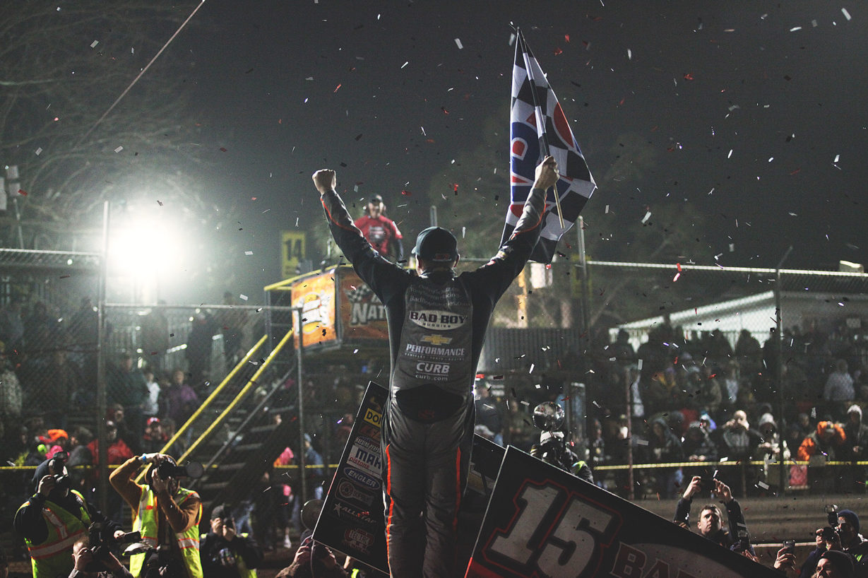 Donny Schatz celebrates in victory lane after capturing the Saturday night World of Outlaws series win at Volusia Speedway in Florida, during Sprint Week at The DIRTcar Nationals. ( Jeffrey Turford / TDP )